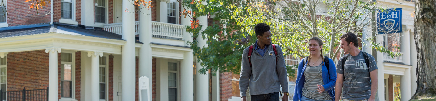 Three students walk by Carriger Hall on the Emory & Henry campus