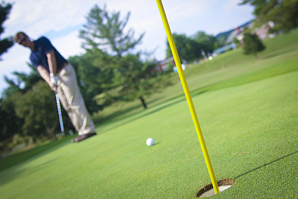 Golfer with golf ball and hole