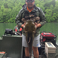 Student holding a large catfish
