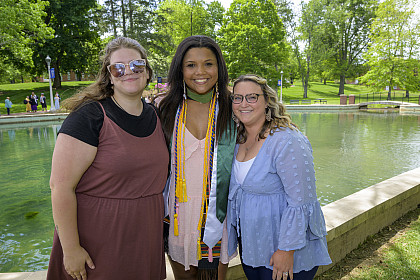 Graduate poses in front of duck pond