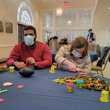 Participants in River's Way make posters to root on the E&H Football Team 