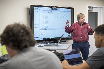 A professor teaching computer programming to a class