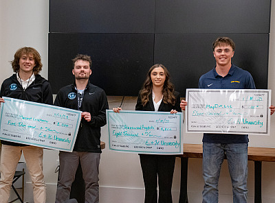 School of Business students holding checks