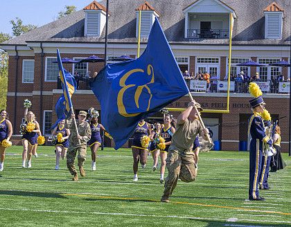 E&H ROTC Cadets running with blue flags