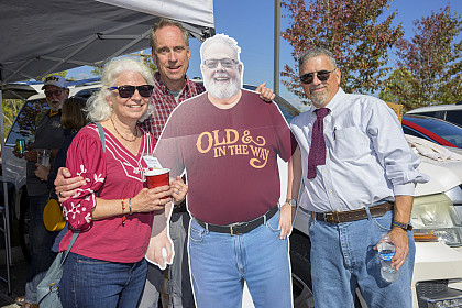 A group of alumni with a cardboard cutout of a person wearing a shirt that says Old in the Way