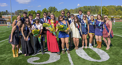A group of students on the football field wearing formal attire