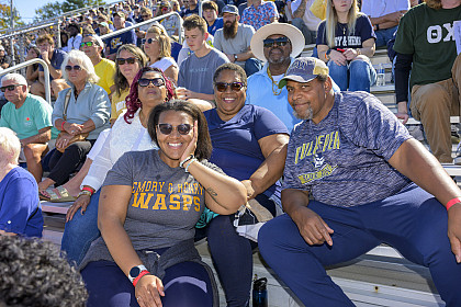 A group of spectators in the bleachers posing for the camera