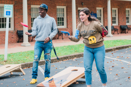 Two Emory & Henry students are playing cornhole.